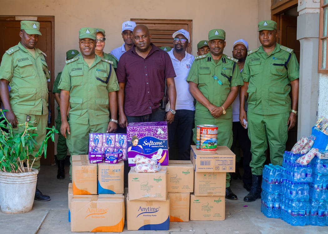 Kanga Foundation Tanzania representatives and Tanzania Police Force officers with sanitary products donated at Jangwani Secondary School